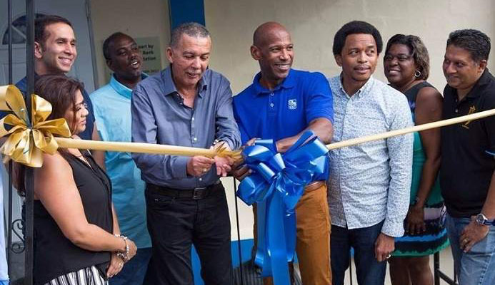 President Anthony Carmona, fourth from left, gets some assistance from RBC's managing director Darryl White, fourth from right, as he cuts the ribbon to officially open Presentation College San Fernando new squash court on Saturday. Photo: EDISON BAKER