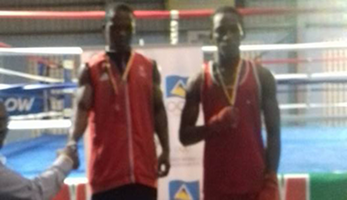 T&T's Justin Parris, L, shake hands with an officials before he was presented with his gold medal last week. He defeated Uriah De Silva, R.