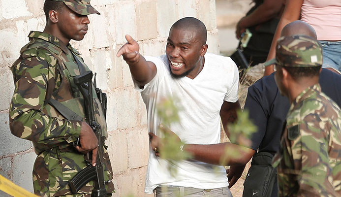 RAGE: Residents often react angrily to the presence of police and soldiers. Here emotions run high at the scene of a double murder in Canada, Laventille.