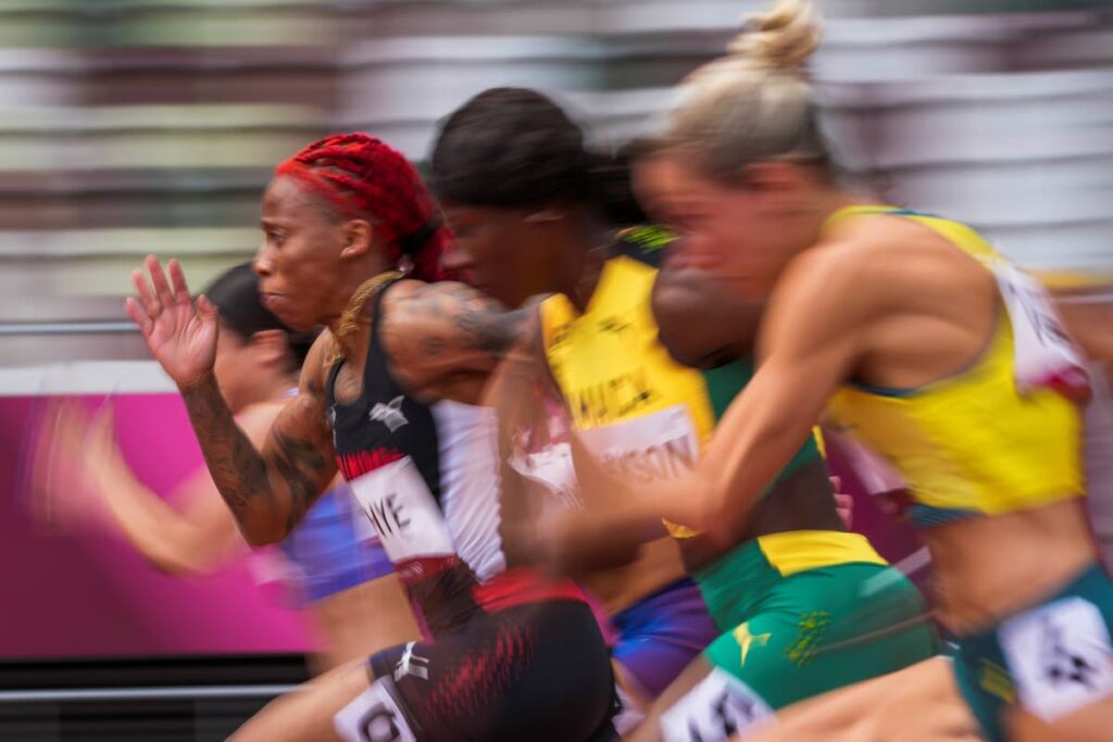 In this July 30 file photo, Michelle-Lee Ahye, left, of Trinidad and Tobago, runs in her heat of the women's 100-meters at the 2020 Summer Olympics, in Tokyo. Ahye was on Wednesday named the TT Olympic Committee's 2021 sportswoman of the year. (AP Photo) -