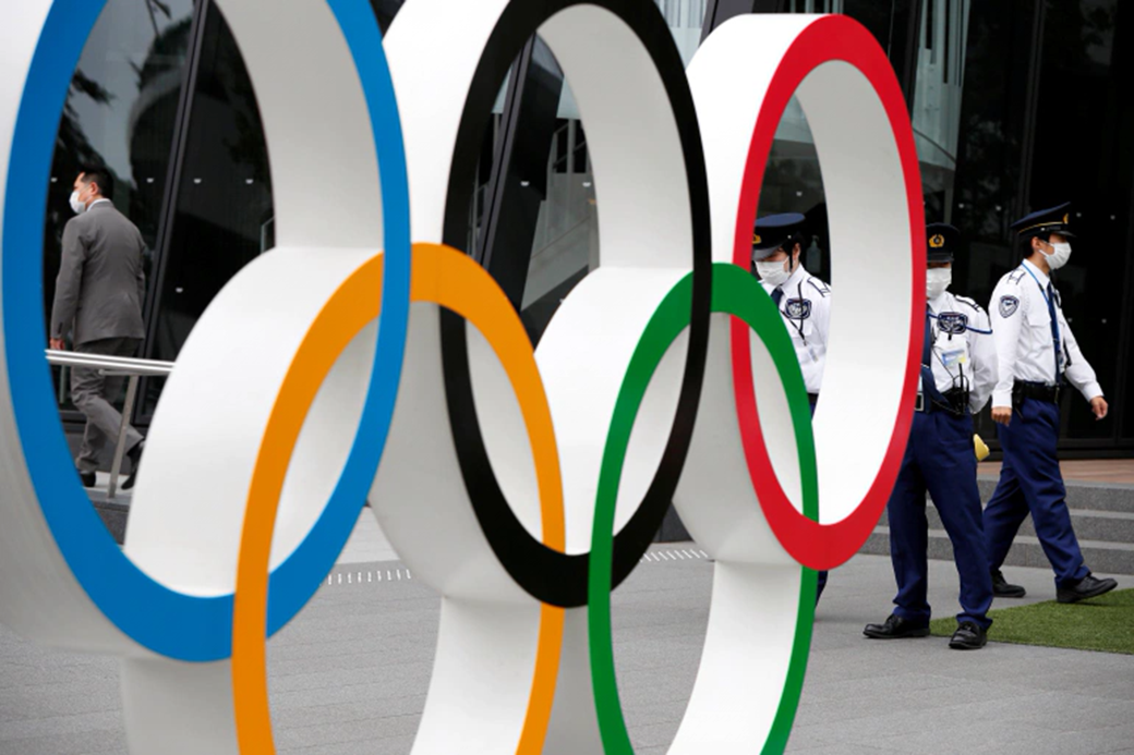 Security personnel stand guard near the Olympic rings monument during a rally by anti-Olympics protesters outside the Japanese Olympic Committee headquarters, amid the coronavirus disease (COVID-19) outbreak, in Tokyo, Japan, May 18, 2021 [Issei Kato/Reuters]