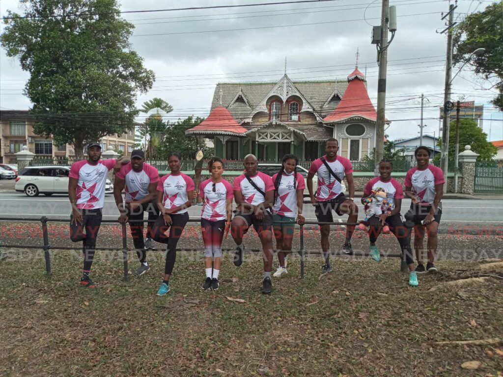 TT women's boxer Tianna Guy, fourth from left, holds the Queen's Baton at the Queen's Park Savannah in Port of Spain, on Wednesday. She is joined by national athletes and former athletes. - Jelani Beckles