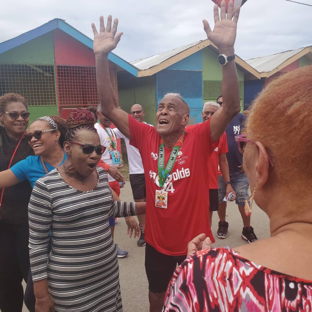 Derrick McIntyre, 84, celebrates completing the 26.2 mile TT Olympic Committee marathon walk at the Queen's Park Savannah, Port of Spain, on Sunday. (Photo obtained at newsday.co.tt)