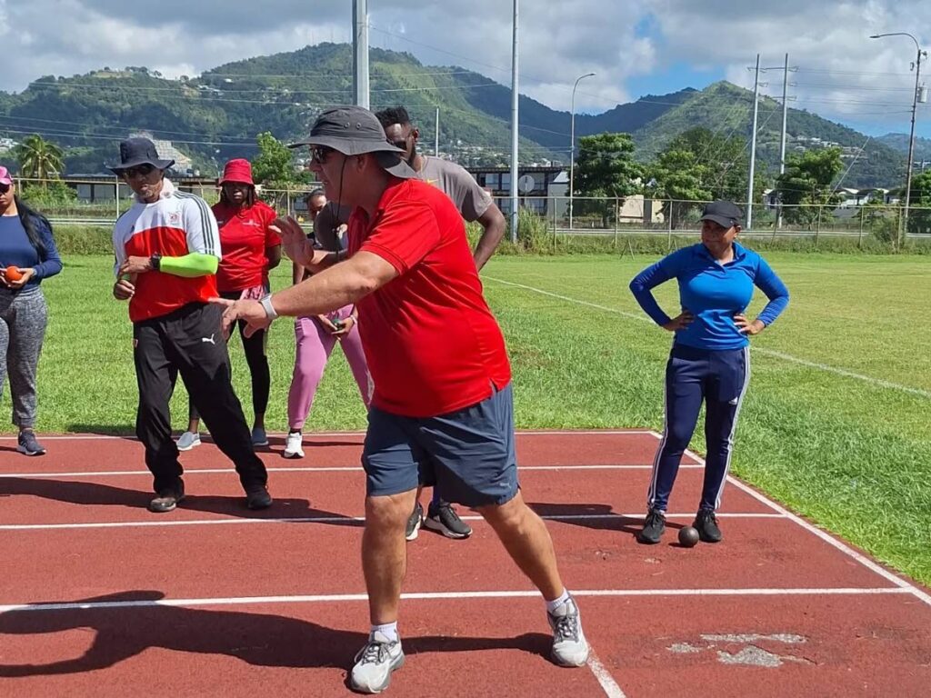 Coach Ismael Lopez Mastrapa shows participants the shot put technique at a Throws Workshop, hosted by the elite athlete wellbeing unit of the Sport Company of TT at the Hasely Crawford Stadium training field, Mucurapo, on October 4. - Photos courtesy SPORTT (Image obtained at newsday.co.tt)