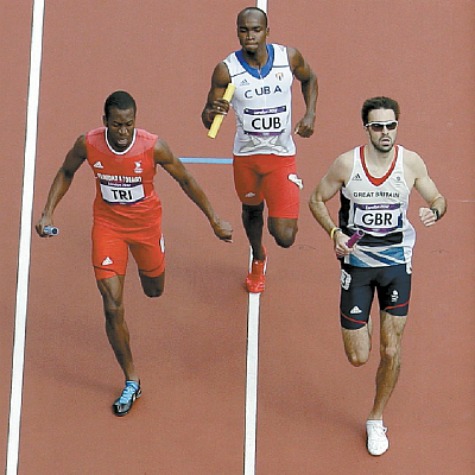 T&T’s Deon Lendore, left, races Cuba’s Omar Cisneros, centre, and Britain’s Martyn Rooney to the finish of a men’s 4 x 400-metre relay heat during the athletics in the Olympic Stadium at the 2012 Summer Olympics, London, yesterday. The T&T quartet took joint first place with Britain in the event. AP Photo